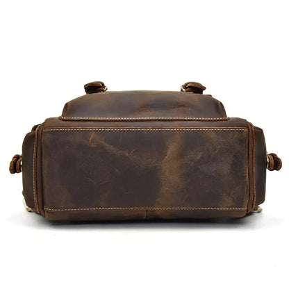 Brown leather backpack back view with top handle and adjustable shoulder strap loops
