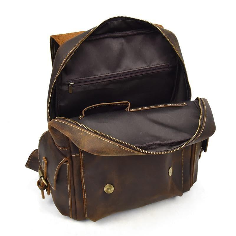 Brown leather backpack with open top, zip compartment, and front pocket with button