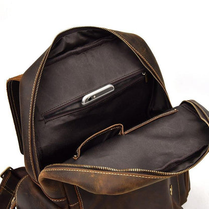 Brown leather backpack open: zip compartment with internal divider and phone slot