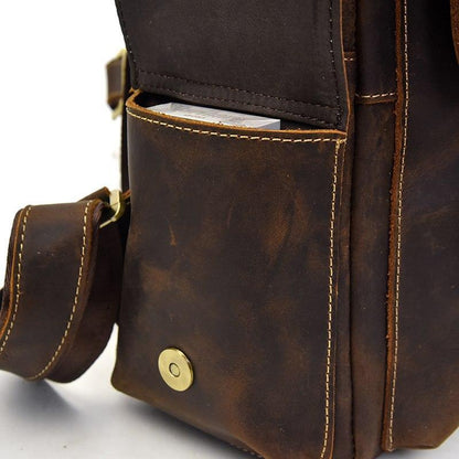 Leather backpack side panel with zipper, stitched trim, and brass snap button