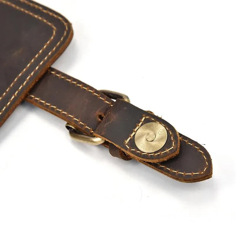 Leather backpack strap with brass-tone buckle and stitched leather keeper