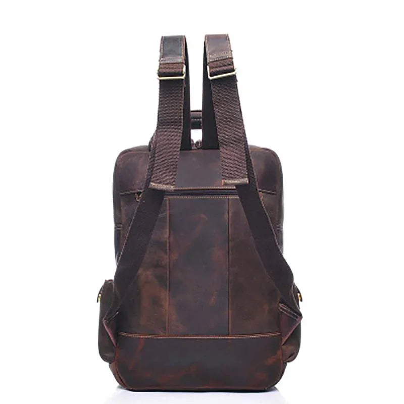 Brown leather backpack with two back straps and rear panel pocket.