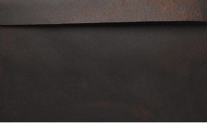 Dark brown leather texture on vintage laptop backpack surface.