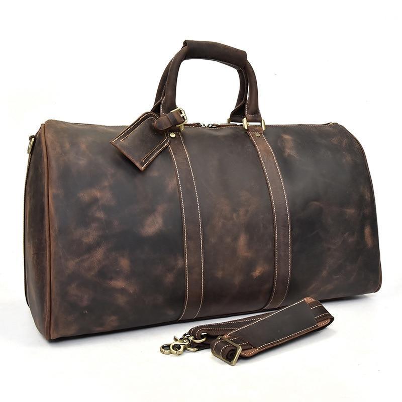 Dark brown leather duffle bag with top handles, stitched straps, and front leather tag.