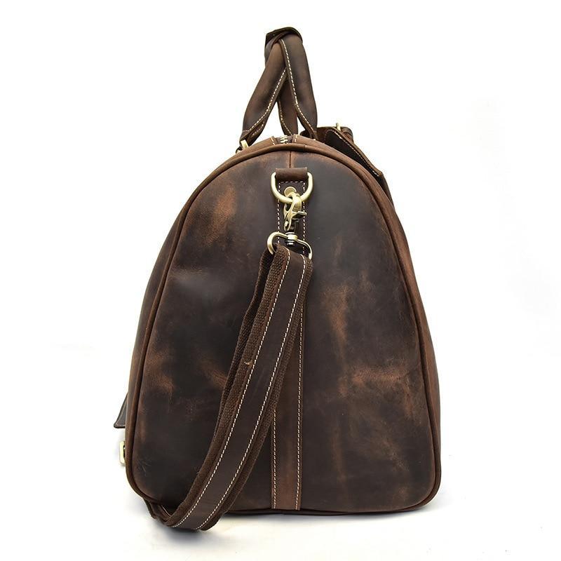 Brown leather duffel bag with top handle straps and crossbody shoulder strap