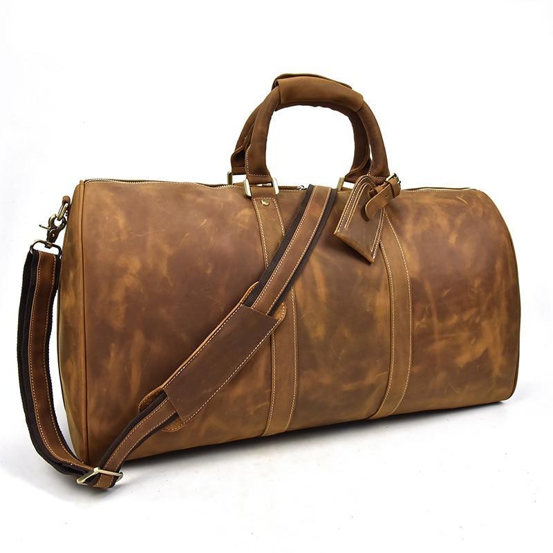Tan-brown leather duffel bag with detachable shoulder strap and front handle tag