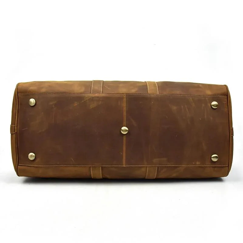 Brown leather duffel bag end panel with snap buttons and stitched seams