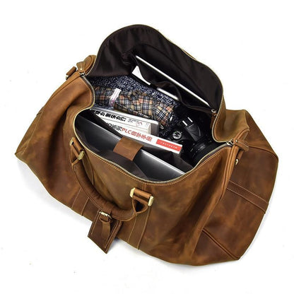 Brown leather duffle bag open to show interior divider, pockets, and zipper compartment.