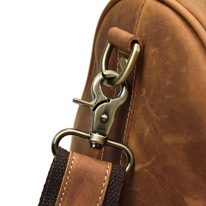 Leather duffel bag close-up of brass clasp hardware on handle strap
