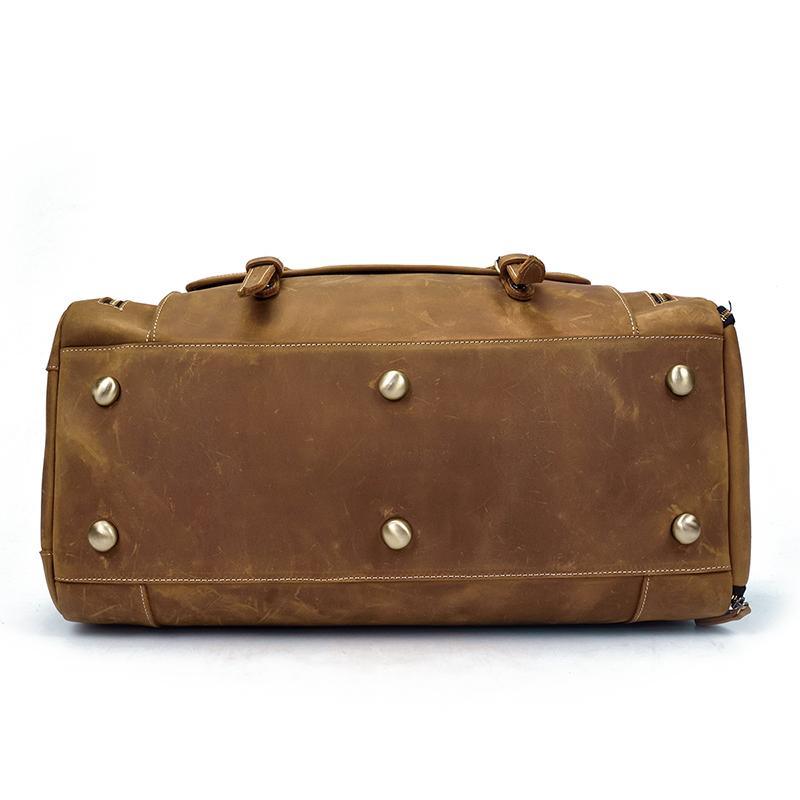 Handmade leather duffle bag in brown with metal stud accents on the front panel