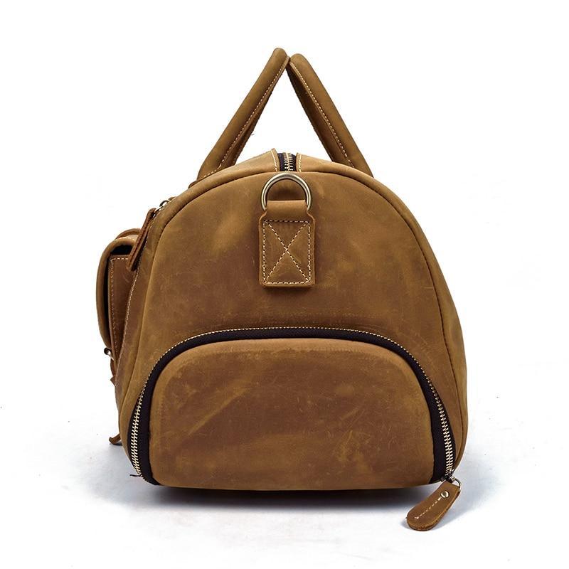 Handmade leather duffle bag in tan brown with front zipper, top handle loop, small front tag
