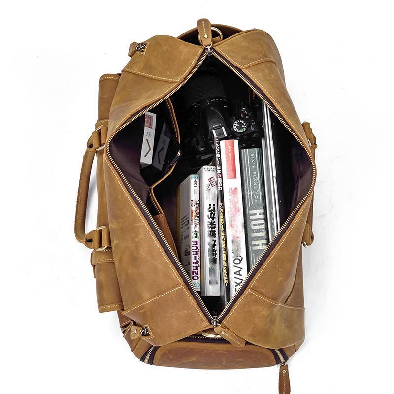 Leather duffle bag open with zipper opening showing folded contents inside