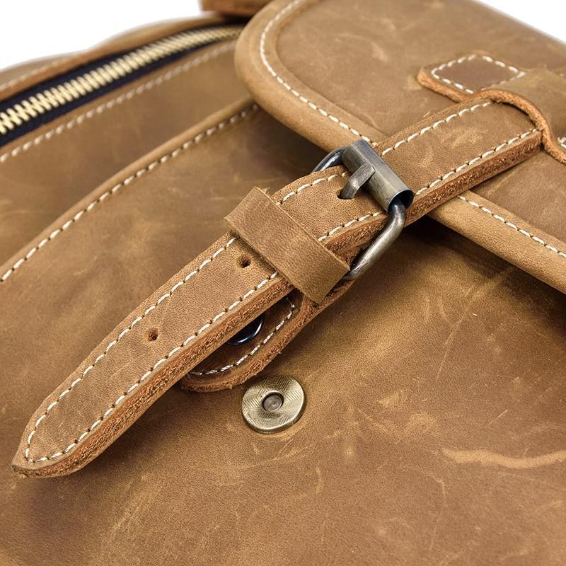 Leather duffle bag strap and buckle detail with stitched edges
