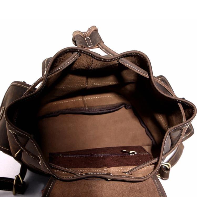 Brown leather rucksack with front flap, open top, and lined interior pockets