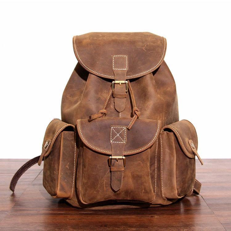 Genuine leather rucksack in brown with front flap, central buckle, and side pockets