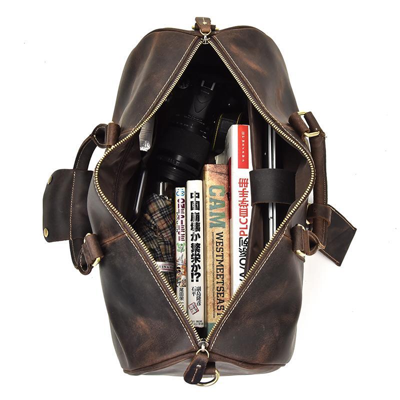 Open small leather duffle bag showing dark interior lining and front zip closure