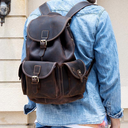 Brown leather rucksack with front flap, two buckles, and side compartments