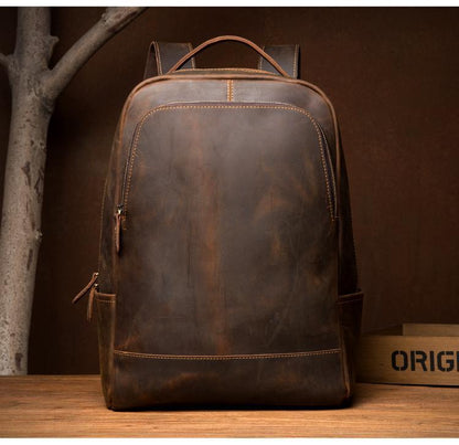 Vintage leather backpack front view with top handle and two side strap attachments