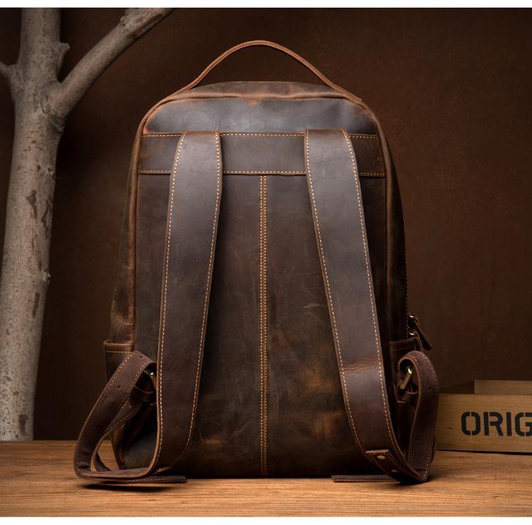 Vintage leather backpack back view with padded straps and top handle in dark brown