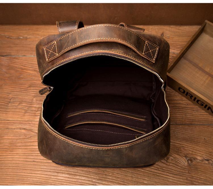 Vintage leather backpack open view showing interior pocket and metal zipper pull