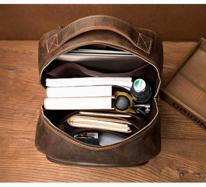 Vintage leather backpack open with visible inner compartments and zipper closure