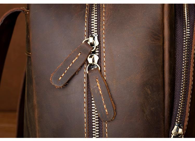 Brown leather backpack close-up of zipper pull and stitched leather tabs