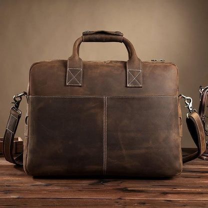 Vintage leather messenger bag in dark brown with structured front, top handle, and side buckles