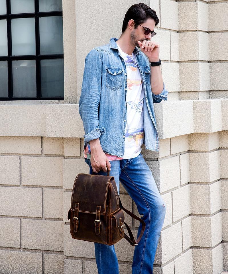 Brown leather backpack worn with shoulder strap, front buckle straps visible