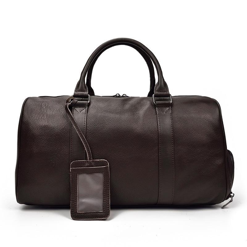 Brown leather weekender duffle bag with top handles and hanging ID tag strap.