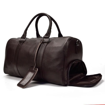 Brown leather weekender duffle bag with top handles and side zip pocket, shown open.
