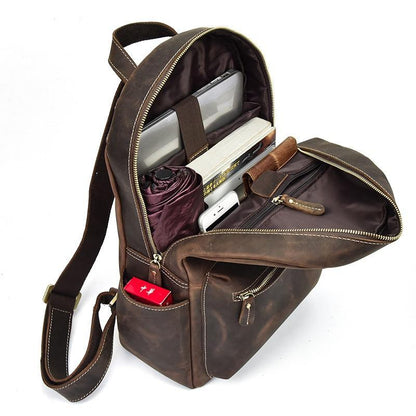 Brown leather backpack with items inside on a white background