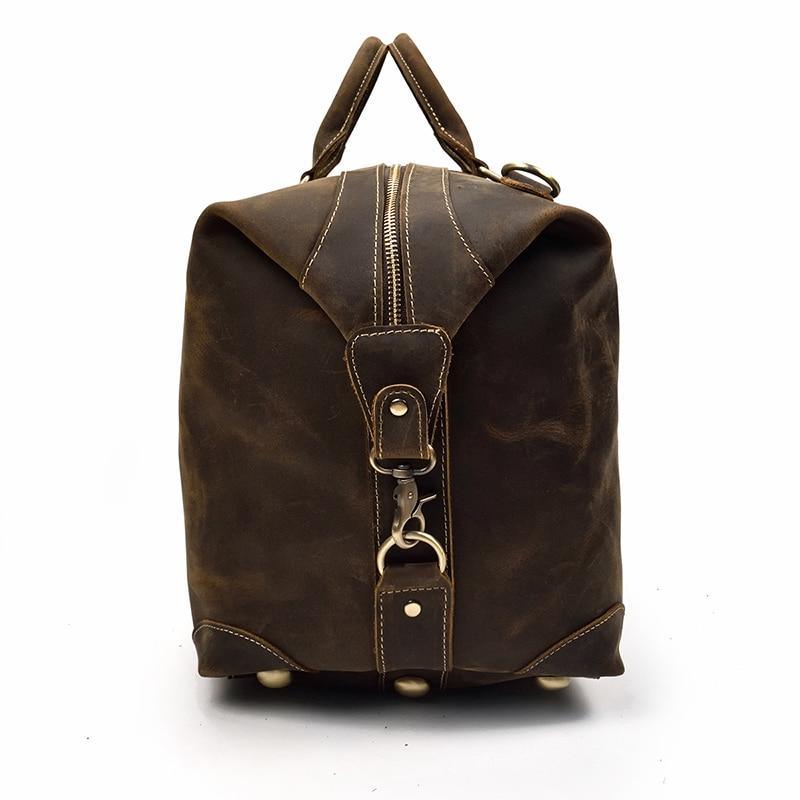 Vintage leather duffle bag with top handle and zip pocket on the back.