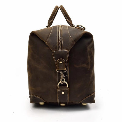 Vintage leather duffle bag with top handle and zip pocket on the back.