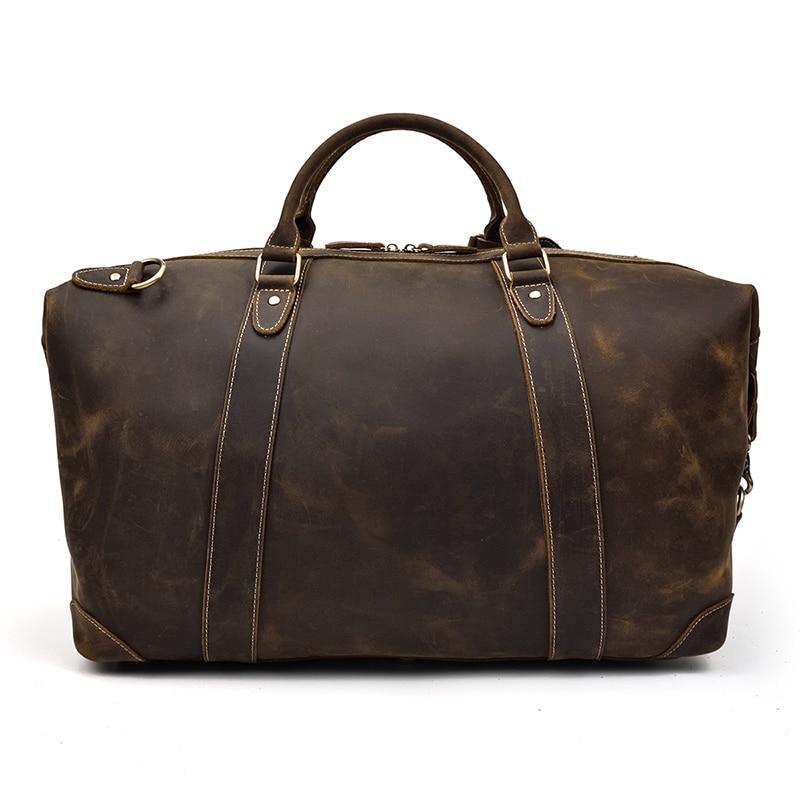 Vintage leather duffle bag in dark brown with two front straps and metal hardware.