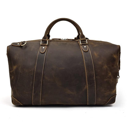 Vintage leather duffle bag in dark brown with two front straps and metal hardware.