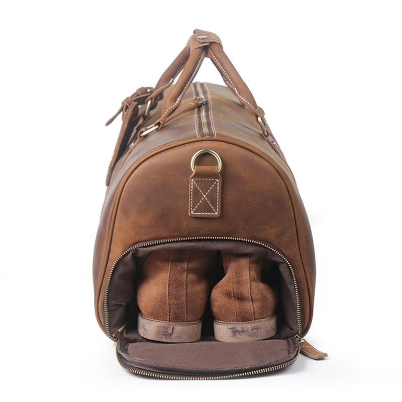 Brown leather duffle bag with U-shaped zipper opening and inner slip pocket at front.