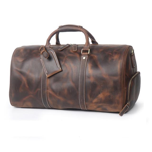 Large brown leather duffle travel bag with top handle, side zipper pocket, and stitched accents.
