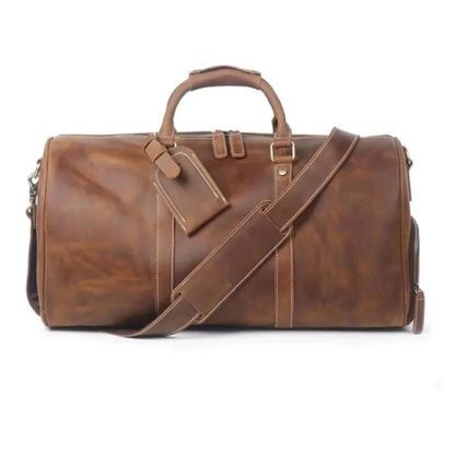 Brown leather large duffle bag with crossbody strap, top handles, and front buckle detail.