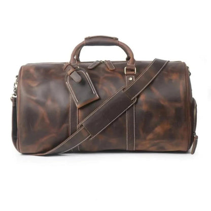 Dark brown leather large duffle bag with crossbody strap, top handles, and front buckle detail.