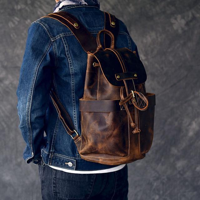 Vintage leather backpack worn on a person, front flap and straps visible