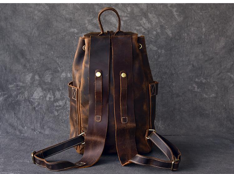 Brown leather rucksack backpack with twin buckle straps and crossbody shoulder strap