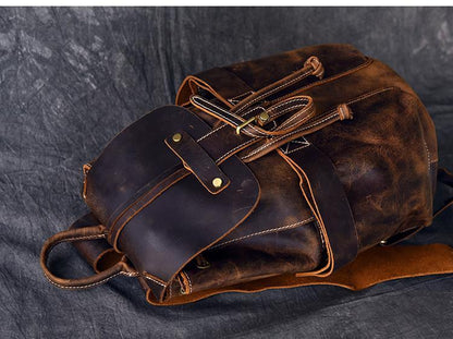 Rolled leather rucksack with side straps, buckle pocket, and stitched details