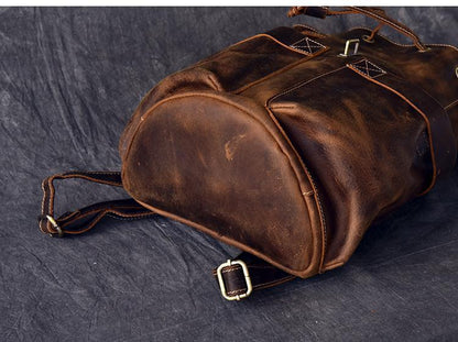 Brown leather duffel-style rucksack with drawcord and metal clasp hardware