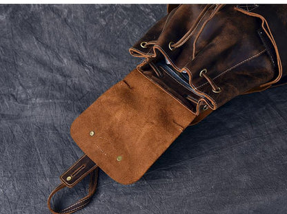 Vintage leather backpack close-up: top flap, metal buckles, and straps