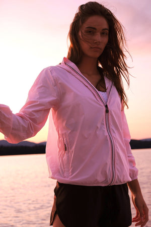 Picture of a Women's Ballet Slipper Full Zip Pink Waterproof Rain Jacket on the lake with a sunset