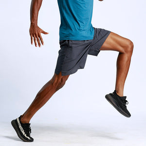 Men's Sports and Fitness Running Shorts action shot of a man stretching in dark grey shorts