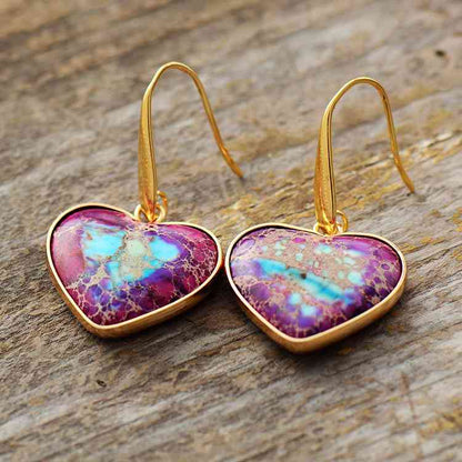 Natural Stone Heart Drop Earrings purple on a wood table