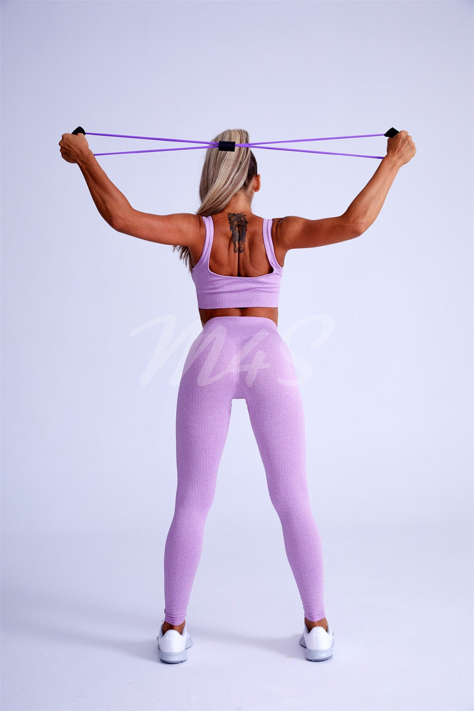 Ribbed Spandex Women's Tracksuit in pink stretching and working out behind