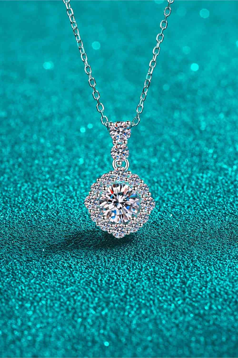 1 Carat Round Moissanite 925 Sterling Silver Necklace over a blue floor