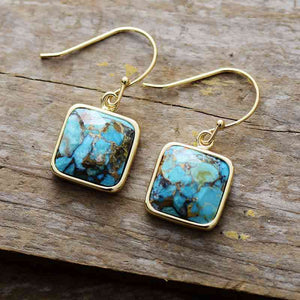 Square Copper Drop Turquoise Earrings on a wood table